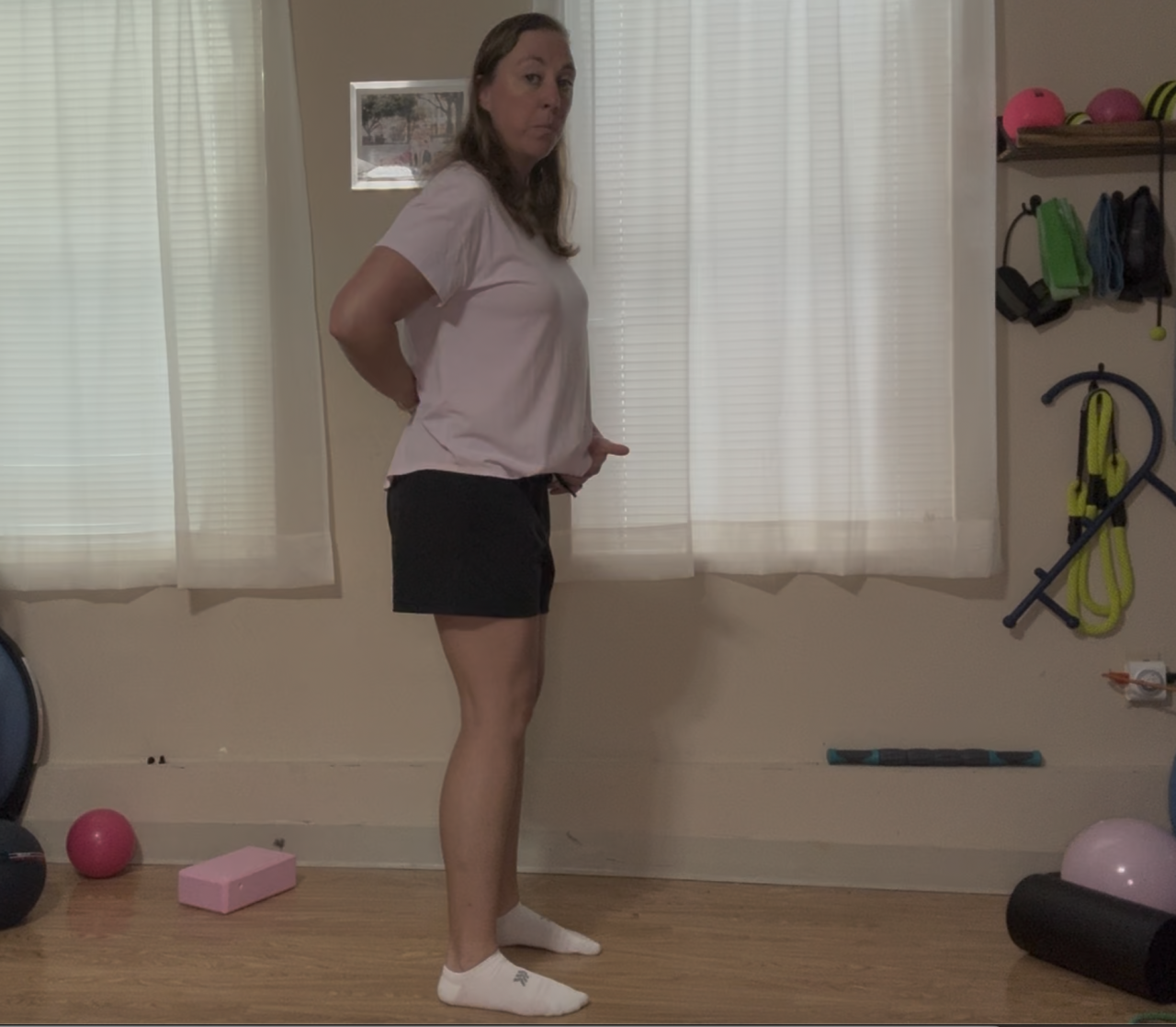 side view of a female holding her low back